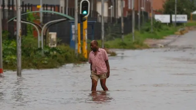 Mtu mmoja akivuka mto wa maji katikati ya mji katika kipindi cha mafuriko nchini South Africa.